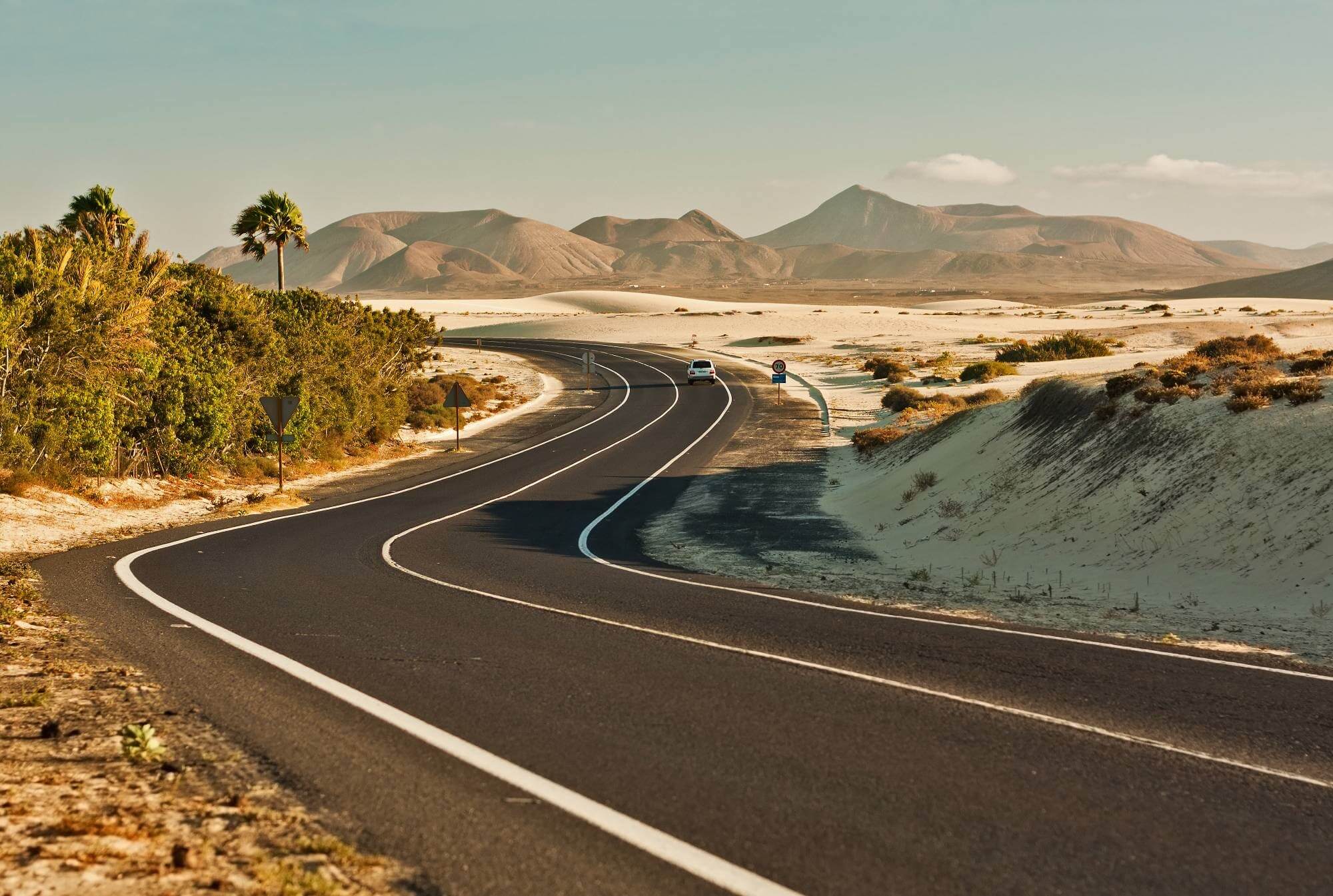 A smooth road winding through a desert landscape.